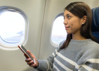 Woman use of cellphone inside airplane