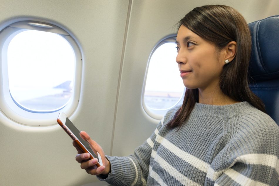 Woman use of cellphone inside airplane