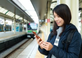 Woman use of mobile phone at train station