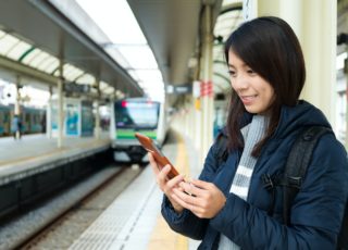 Woman use of mobile phone at train station