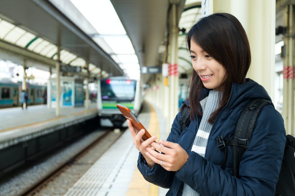 Woman use of mobile phone at train station